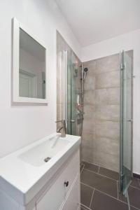 y baño blanco con lavabo y ducha. en River Side Apartment Old Town en Gdansk