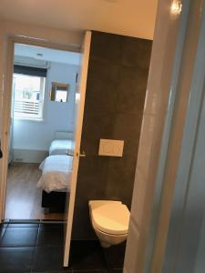 - une salle de bains avec toilettes et un lit dans une chambre dans l'établissement Apartment de Boer, à Zandvoort
