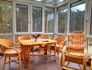 a screened in porch with a wooden table and chairs at Haus Freyja Ferienwohnungen in Graal-Müritz