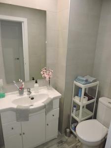 a bathroom with a white sink and a toilet at Conil Apartment in Conil de la Frontera +15 photos