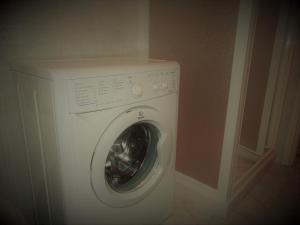 a white washing machine in a corner of a room at Mi.Ma's dream in Milano Marittima