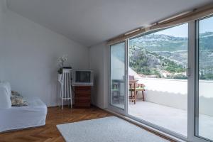 a bedroom with a bed and a sliding glass door at Apartment Matijas in Trstenik