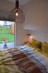 a large bed in a bedroom with a large window at Wadzand in Midsland