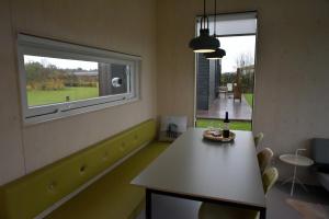 Habitación con mesa y ventana con botella de vino en Wadzand en Midsland