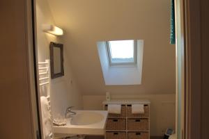 baño blanco con lavabo y ventana en La Margot'ine, en Montrieux-en-Sologne