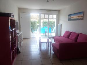 a living room with a purple couch and a table at 2 pieces a la teste de buch in La Teste-de-Buch