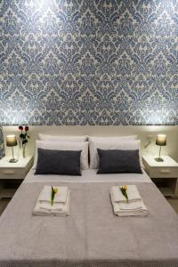 ein Schlafzimmer mit einem Bett mit zwei Handtüchern und Blumen darauf in der Unterkunft lungomare rooms in Castellammare di Stabia
