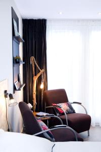 ミデルブルフにあるStudio-Vrijの椅子2脚、テーブル、窓が備わる客室です。