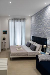 um quarto com uma cama grande e um sofá em lungomare rooms em Castellammare di Stabia