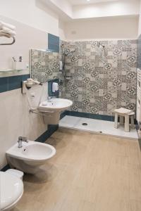 ein Bad mit einem Waschbecken, einem WC und einer Dusche in der Unterkunft lungomare rooms in Castellammare di Stabia