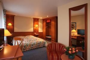 una stanza d'albergo con un letto e uno specchio di Hotel Gruber a Steinheim