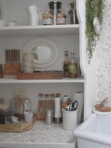 a shelf with dishes and utensils in a kitchen at La chambre blanche in Heerlen