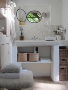 uma casa de banho com um lavatório e um espelho em La chambre blanche em Heerlen