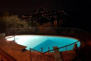 a large blue swimming pool at night with lights at Villa panoramica tra suggestive notti stellate. in Torre delle Stelle +19 photos