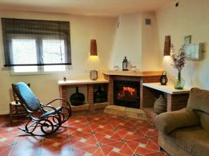 a living room with a fireplace and a chair at Cortijo Claudia in Taberno