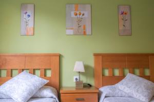 a bedroom with two beds and paintings on the wall at Apartamento Sella y Mar - VUT12AS in Ribadesella