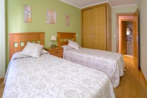 a bedroom with two beds and a bathroom at Apartamento Sella y Mar - VUT12AS in Ribadesella