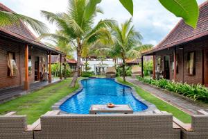 a pool in the courtyard of a villa at Arton Resort & Beach Club in Pulukan