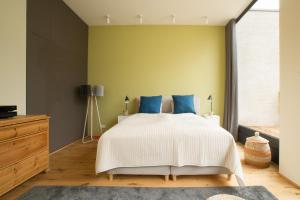 ein Schlafzimmer mit einem großen Bett mit blauen Kissen in der Unterkunft An der Mauer 15 in Lübeck