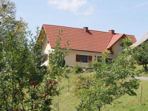 una casa con techo rojo en una colina con árboles en Kogelhuber en Pössnitz