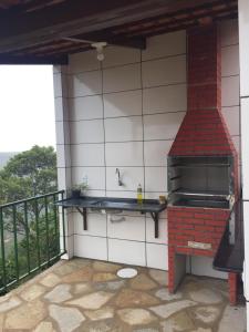 an outdoor kitchen with a red brick oven on a balcony at Pousada Recanto das Pedras São Leopoldo in Pirenópolis
