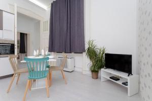 a living room with a table and a television at Boutique Residence Jokai - Apartment in the city center in Budapest