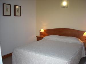 a bedroom with a white bed and two lamps at Moradias do Douro Internacional in Freixo de Espada à Cinta