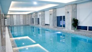 a large swimming pool with blue water in a building at ART Hotel in Kirov