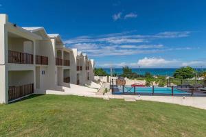 a view of a building with a pool and the ocean at Family Complex beside Beach w/Pool Montego Bay #1 in Montego Bay