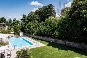 een zwembad in een tuin naast een steunmuur bij Sweet Hotel in Longa