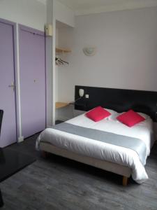 a bedroom with a large bed with red pillows at L'Ecailler in Ouistreham