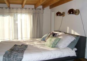 a bedroom with a large bed with white sheets and pillows at watervilla-albertje in Amsterdam