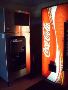 uma máquina de Coca-Cola laranja e branca ao lado de uma máquina de venda automática em Gateway Inn Savannah em Savannah