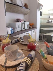 a table with cups of tea and jars of jam at Dimore di Mare in San Pietro Vernotico