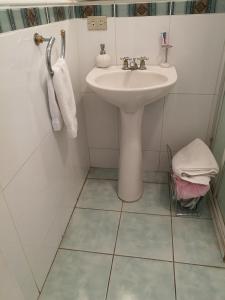 グアテマラシティにあるCasa familiar La Arboledaのタイルフロアの白いバスルーム(シンク付) +20枚の写真