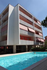 a building with a swimming pool in front of a building at Gabbiano - Appartamenti in Bibione