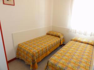 a room with two beds and a window at Gabbiano - Appartamenti in Bibione