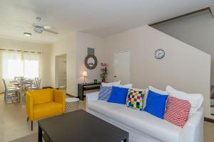 a living room with a white couch and a yellow chair at Family Complex beside Beach w/Pool Montego Bay #1 in Montego Bay