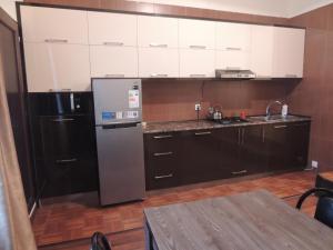 a kitchen with white cabinets and a stainless steel refrigerator at Apartment on St. Nikoloz Baratashvili 1 in Batumi
