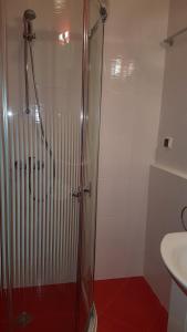 a bathroom with a glass shower with a sink at Zefira Apartments in Pomorie +12 photos
