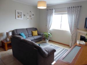 a living room with a couch and a window at Near Beach Apartment in Póvoa de Varzim