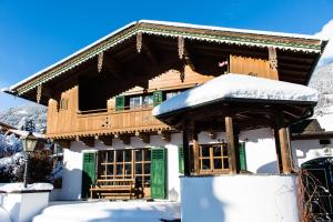 a wooden house with snow on the roof at Landhaus Wanger in Neukirchen am Großvenediger