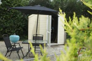 a table and chairs and an umbrella in front of a shed at The annex, Ruthvose in Saint Columb Major +9 photos