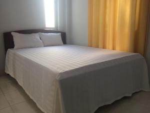 a bedroom with a bed with a white bedspread at Y Bon in Phan Thiet