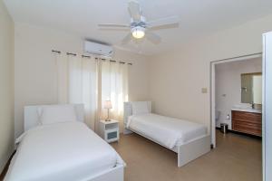 a bedroom with two beds and a ceiling fan at Family Complex beside Beach w/Pool Montego Bay #2 in Montego Bay +44 photos