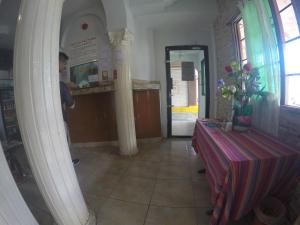 mężczyzna stojący w pokoju ze stołem i kolumnami w obiekcie Backpacker Inn w Panamie