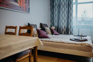 a room with a bed with a table and a window at Grey Apartments II in Wrocław