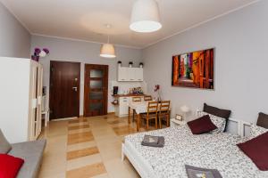 a living room with a bed and a dining room at Grey Apartments II in Wrocław