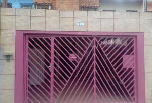 una porta rosa di metallo su un edificio con di Residencia familiar a San Paolo