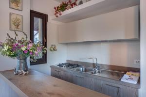 kuchnia ze zlewem i wazonem kwiatów na ladzie w obiekcie Appartamento al Forte di Talamonaccio w mieście Fonteblanda